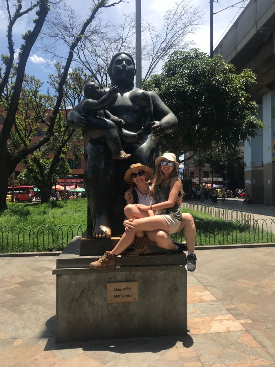 Lanna Sanches sentada no colo de sua mãe posando para uma foto de viagem