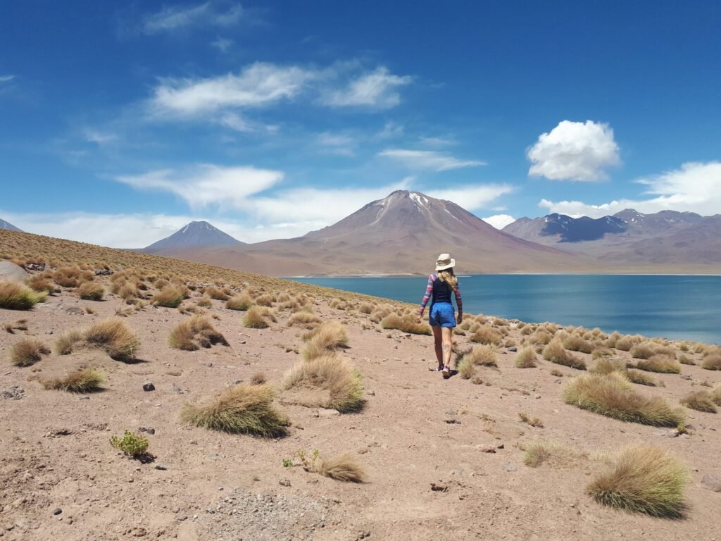 Paisagem de uma Laguna no Deserto do Atacama com uma mulher andando de costas